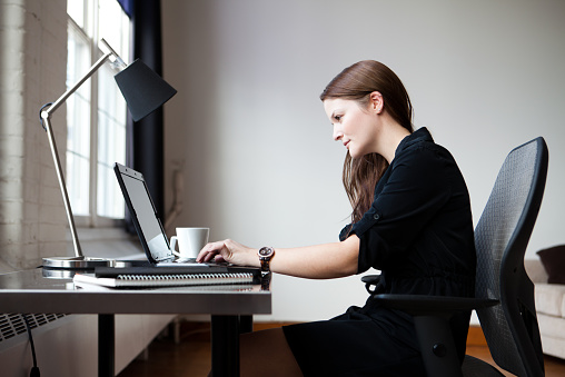 femme utilisant une lampe de bureau pour travailler